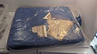 Entire sealed blue tarp in plastic wrap with tags visible