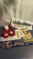 All memorabilia items laid out: mittens, pennant, tea towel, program, Expo 86 card, stamp sheet