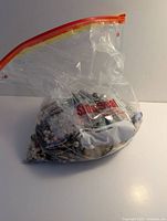 Sealed bag of mixed jewelry showing contents