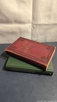Two hardcover books stacked: red The Book of Knowledge and green Fireside Tales