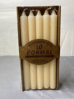 Front of sealed box showing five visible ivory tapers and branding