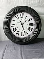 Front view of round wall clock showing dial and frame