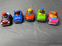 Front view of the five Little People Wheelies vehicles