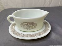 Side view of gravy boat on under plate showing Woodland floral pattern