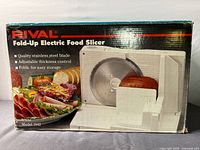 Front of retail box showing Rival Fold-Up Electric Food Slicer image and specifications