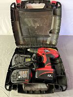 Open case showing Skil drill, charger, two batteries, internal case compartments