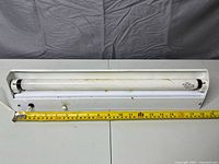 Fixture front view with tape measure showing 18.5 in length, cord and switch visible