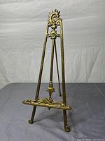Front view of brass-tone easel showing decorative details