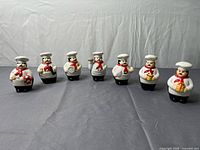 Front view of all seven ceramic chef shakers