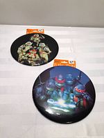 Two oversized TMNT buttons with header cards visible