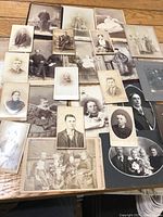 Overhead view showing majority of antique photos spread on wooden surface