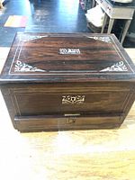 Top view of dark wood jewelry box showing floral inlay decoration on lid