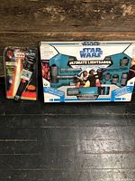 Both Star Wars lightsaber toys: boxed kit and carded game