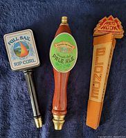 Front view of three tap handles showing graphics and shape