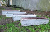 Four wooden planter boxes on ground showing overall condition