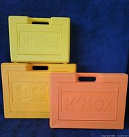 Front view of three K'Nex plastic carrying cases stacked