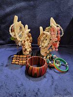 full lot showing bracelets on two display hands and loose bangles