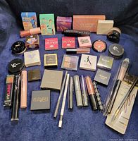 Wide shot showing complete lot of unopened makeup items and brush