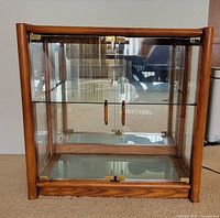 Front view of wood-framed glass cabinet with doors closed