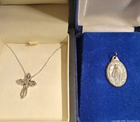 Cross necklace and Mary pendant in their boxes