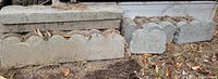 Stack of full-length concrete scalloped edging pieces and two additional pieces to right