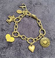 Full bracelet showing all six charms on grey fabric background