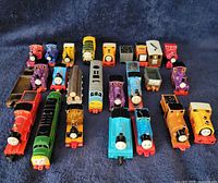 Top view showing all 25 Thomas & Friends miniature train engines and cars arranged in rows