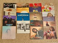 Fifteen album fronts laid out on carpet