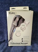 Front of retail box showing Wahl Professional Massager and included attachments