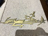 Front view of brass seabird wall hanging showing design and finish