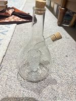Glass cruet showing body, side spout, corks, internal grape cluster