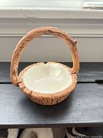 Overall view of ceramic basket showing exterior faux wood texture and cream glazed interior