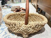 Side view of woven seagrass basket showing texture and wooden handle