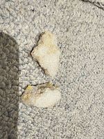 Two small quartz druzy geode clusters on textured surface