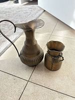 Front view of brass ewer and vase showing sizes and shapes