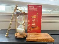 Hourglass with brass frame, oak ends, detached oak base and original red Sears box