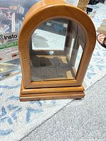 Front view showing arched glass door and wood frame