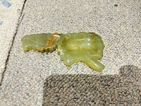 Top view of small multicolor polished stone ashtray showing shape, color, finish, and surface chips