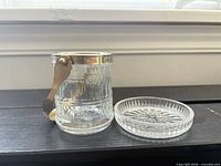 Jar with metal rim and handle alongside matching round tray