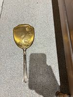 Back of mirror with floral engraving and gold-tone finish