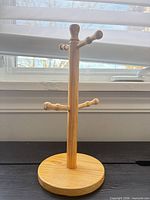 Front view of wooden mug tree showing all four pegs and base