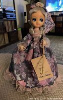 Full view of Bradley musical doll in floral gown holding parasol