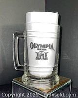 Front view of Olympia Beer glass mug showing logo and handle