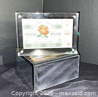 Front view of ticket in acrylic block showing rose graphic and seat details