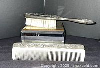 Hairbrush and comb front view showing silver-plated decoration and bristles