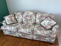 Front view of floral three-seat sofa with cushions