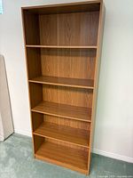 Front view of the five-shelf bookcase showing overall condition and shelf layout