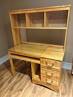 Front view of solid wood desk with hutch, drawers, keyboard tray, glass insert