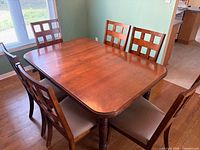 Dining table with six chairs around, showing overall condition and style