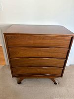 Front view of solid wood 4-drawer dresser showing design and condition